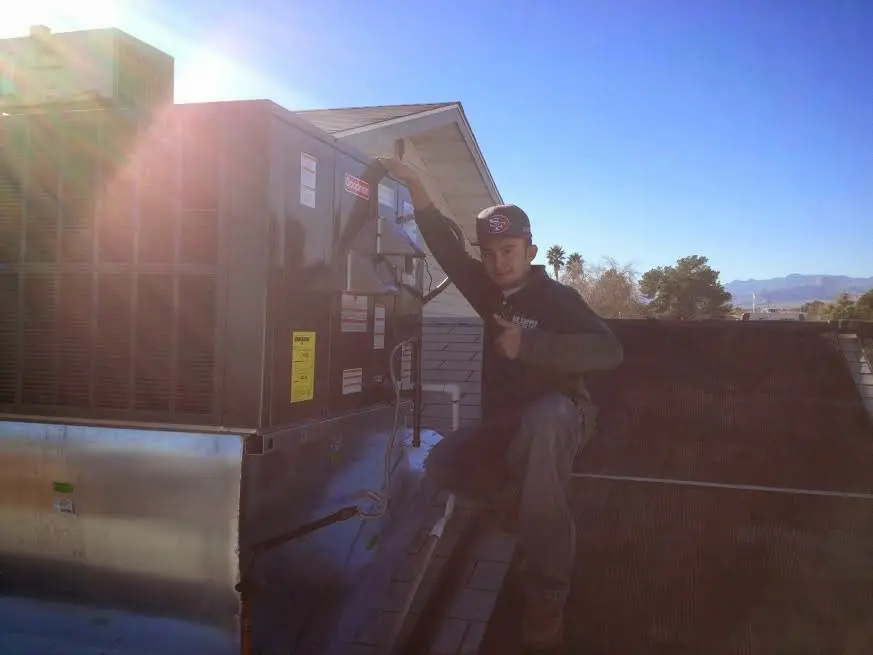 HVAC technician performing Boiler Repair on a rooftop unit in Smithfield